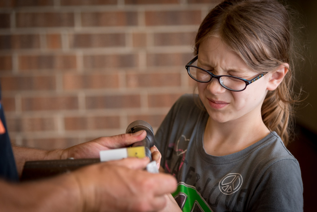 All the kids had the chance to try out the process of prepping metal for rivets and setting them in a piece of aluminum. Here, Phoenix is working with a JAARS member who volunteered to help the kids to make aluminum/rivet letters for their initials. She's not too excited about the noise of the pneumatic rivet buster.